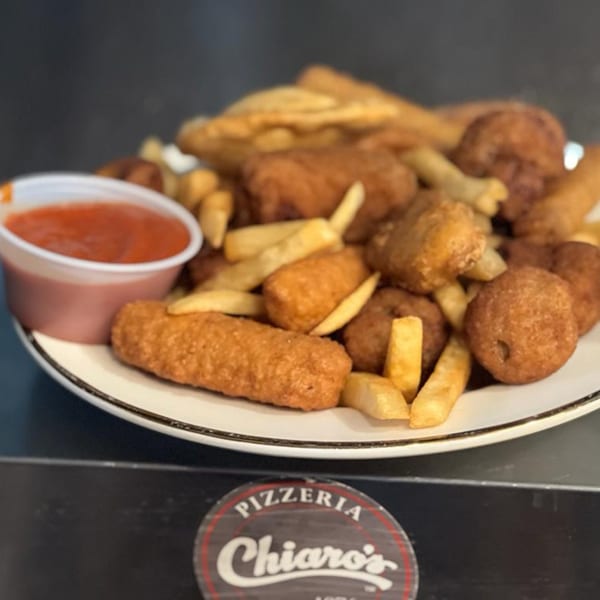 A plate of golden-brown fried appetizers, including mozzarella sticks, fries, and other fried bites, with a side of red dipping sauce.
